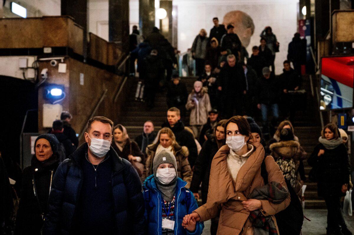 A family wearing a face mask walk in Biblioteka Imeni Lenina metro station in Moscow, Russia on Feb. 7, 2020. (Dimitar Dilkoff/AFP via Getty Images)