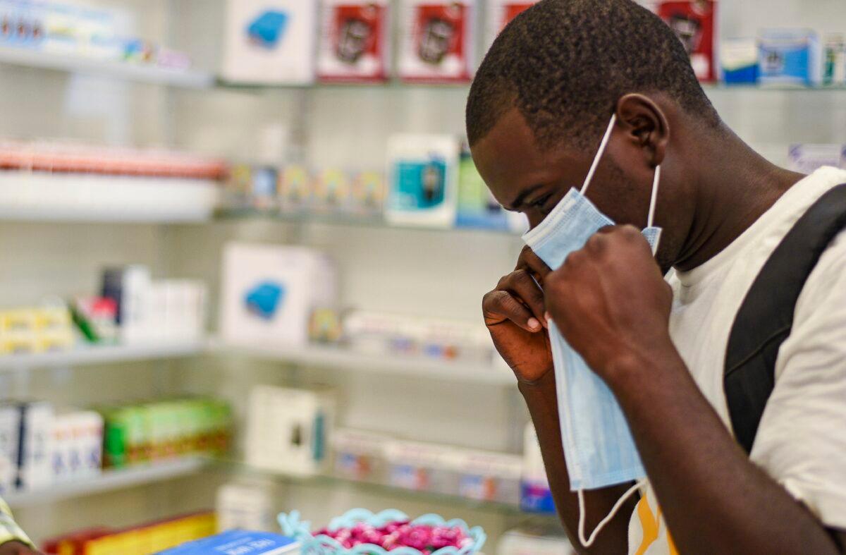In this Feb. 6, 2020, photo, a man tries on a face mask at a pharmacy in Kitwe, Zambia. (Emmanuel Mwiche/AP Photo)