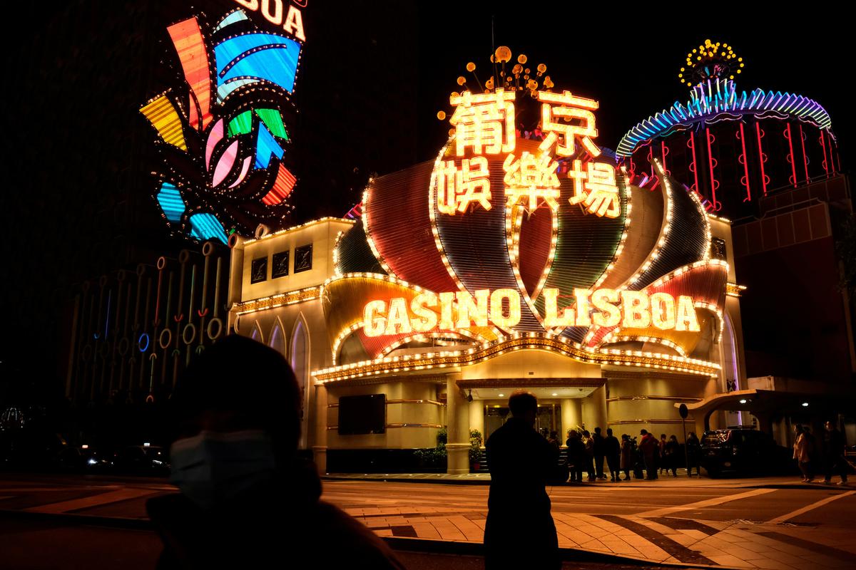 People wearing masks walk in front of Casino Lisboa, before its temporary closing following the coronavirus outbreak, in Macau, China on Feb. 4, 2020. (Tyrone Siu/Reuters)