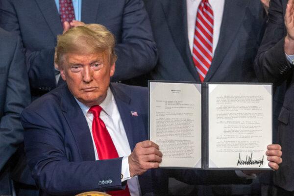 U.S. President Donald Trump ceremonially signs legislation related to water use at a rally with local farmers in Bakersfield, Calif., on Feb. 19, 2020. (David McNew/Getty Images)
