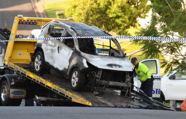A tow truck operator removes a car from the scene of a car fire that claimed the lives of a man and his three children in Brisbane, Feb. 19, 2020. (AAP Image/Dan Peled)