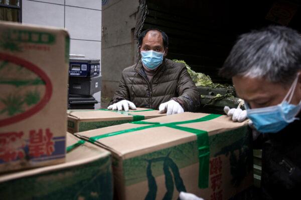Employees wear a protective masks whilst carrying vegetables from trucks at a hospital in Wuhan, China, on Feb. 10, 2020. (Getty Images)