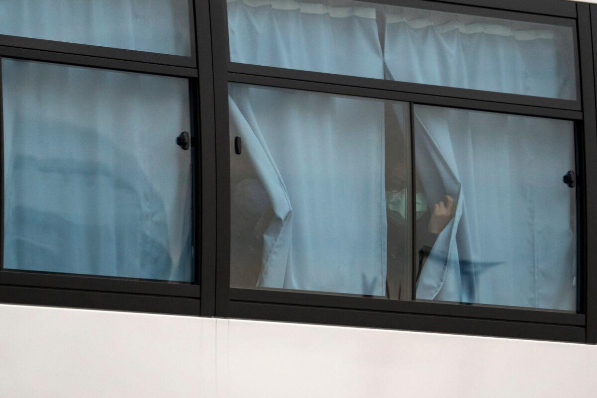 A passenger looks out from a bus as she leaves the quarantined Diamond Princess cruise ship at the Daikoku Pier in Yokohama, Japan, on Feb. 20, 2020. (Tomohiro Ohsumi/Getty Images)