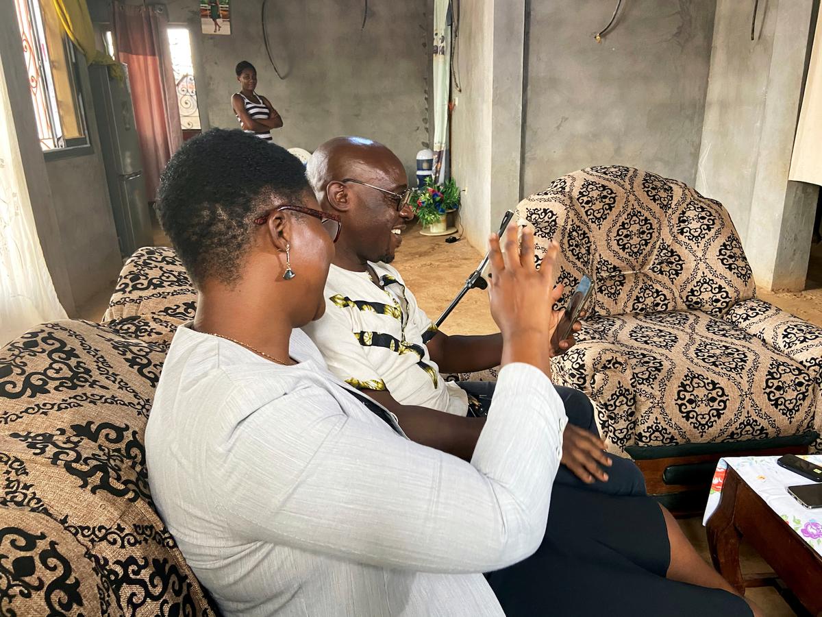 Roger Michel Kemkuining, a teacher in an electrical engineering school, holds a video call with his son, Pavel Daryl Kem, 21, a student, who is infected with the coronavirus in China, as he sits with his wife Albertine at their house in Douala, Cameroon, on Feb. 14, 2020. (Josiane Kouagheu/Reuters)