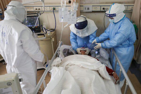 Medical staff members treat a patient infected by the COVID-19 coronavirus at the Wuhan Red Cross Hospital in Wuhan, Hubei province, China, on Feb. 16, 2020. (STR/AFP via Getty Images)