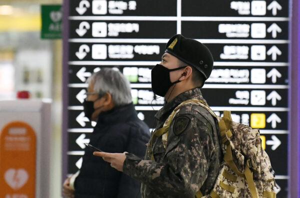 A South Korean soldier (R) wearing a face mask looks at train departure timetable at a railway station in the southeastern city of Daegu, South Korea, on Feb. 21, 2020. (JUNG YEON-JE/AFP via Getty Images)