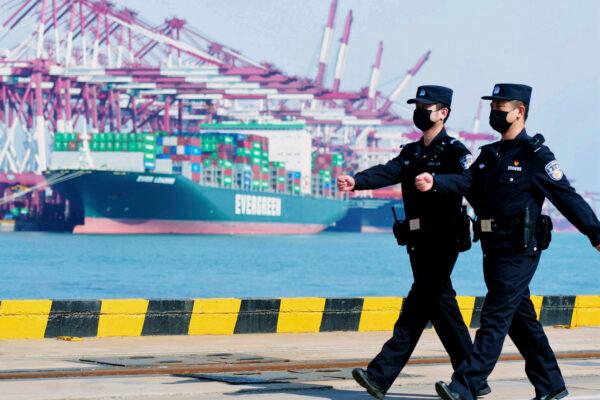 Police officers wearing face masks patrol at a container port in Qingdao in eastern China’s Shandong Province, China on Feb. 19, 2020. (Chinatopix/AP)