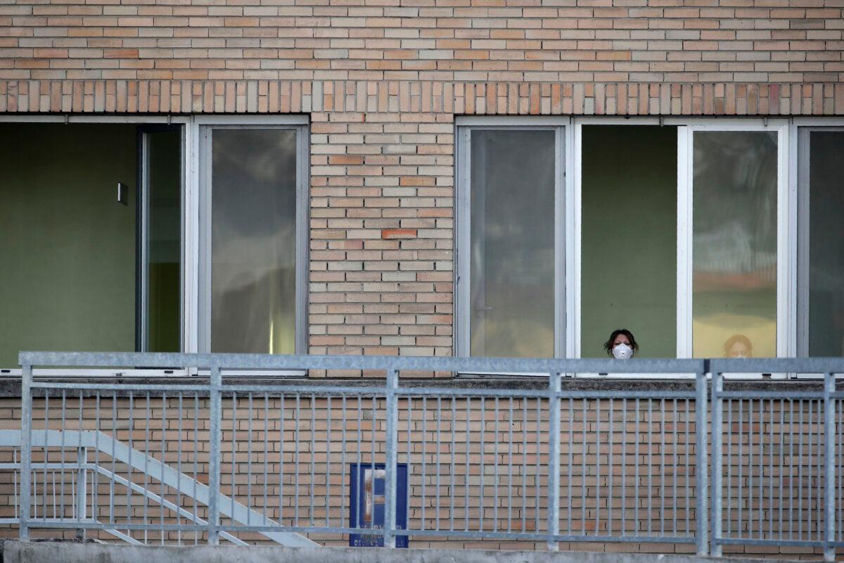 A nurse wearing a sanitary mask watches from a window of the hospital of Codogno, near Lodi in Northern Italy on Feb. 21, 2020. (Luca Bruno/AP Photo)