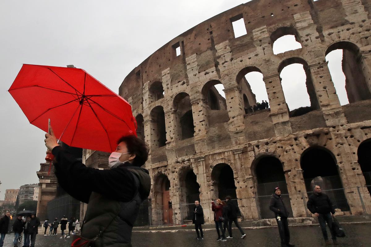 A tourist wearing a mask takes a selfie in front of Rome's ancient Colosseum on Feb. 1, 2020. (Alessandra Tarantino/AP Photo)