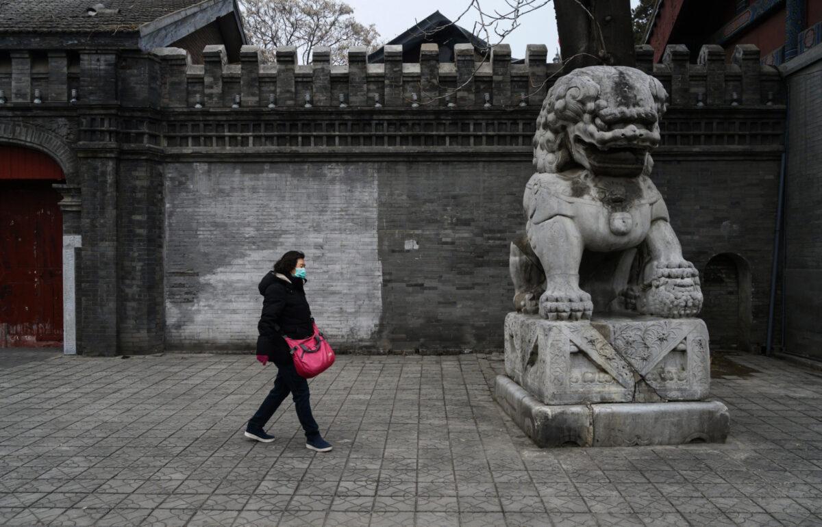 A Chinese woman wears a protective mask as she walks in the street in Beijing, China, on Feb. 20, 2020. (Kevin Frayer/Getty Images)