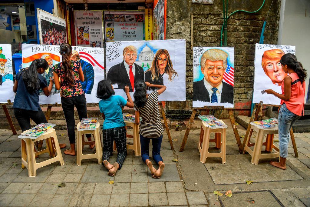 Students paint on canvas faces of President Donald Trump, First Lady Melania Trump, and India's Prime Minister Narendra Modi in the street in Mumbai, India, on Feb. 21, 2020. (Indranil Mukherjee/AFP via Getty Images)
