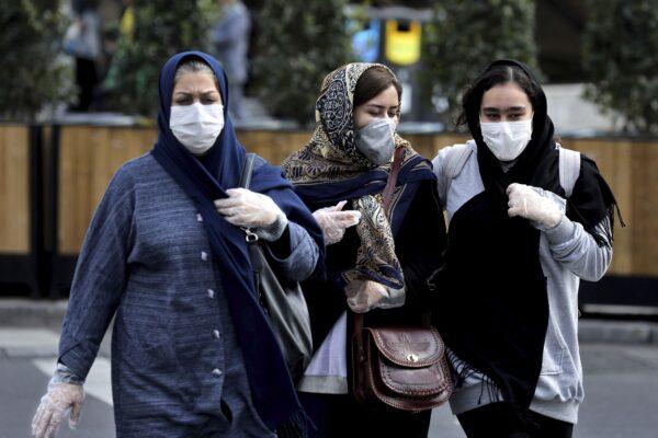 Women wear masks and gloves to help guard against the coronavirus in downtown Tehran, Iran, on Feb. 23, 2020. (Ebrahim Noroozi/AP Photo)