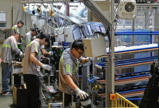 Employees work on an automobile air conditioning production line at a factory in Yantai in China's eastern Shandong Province on May 15, 2019. (STR/AFP via Getty Images)