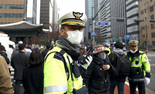 A South Korean policeman wearing a mask to prevent the coronavirus (COVID-19) walks along the street in Seoul on Feb. 22, 2020. (Chung Sung-Jun/Getty Images)