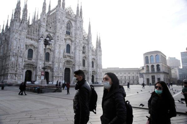 People wearing sanitary masks walk past the Duomo gothic cathedral in Milan, Italy, on Feb. 23, 2020. (Luca Bruno/AP Photo)