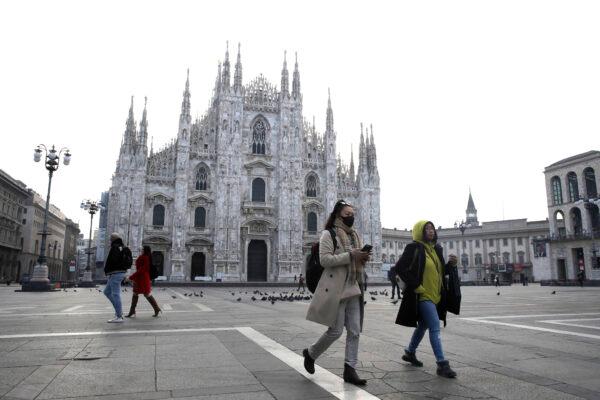 A woman wearing a sanitary mask walks past the Duomo gothic cathedral in Milan, Italy, on Feb. 23, 2020. (Luca Bruno/AP Photo)