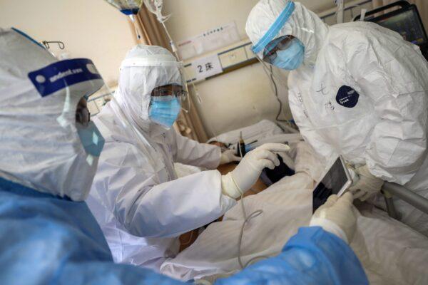 Medical personnel scan a new coronavirus patient at a hospital in Wuhan in central China's Hubei province on Feb. 16, 2020. (Chinatopix via AP)