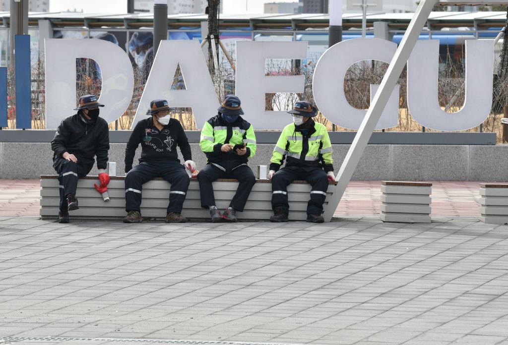 People wearing face masks sit in front of Dongdaegu railway station in the southeastern city of Daegu, South Korea, on Feb. 24, 2020. (Jung Yeon-je/AFP via Getty Images)