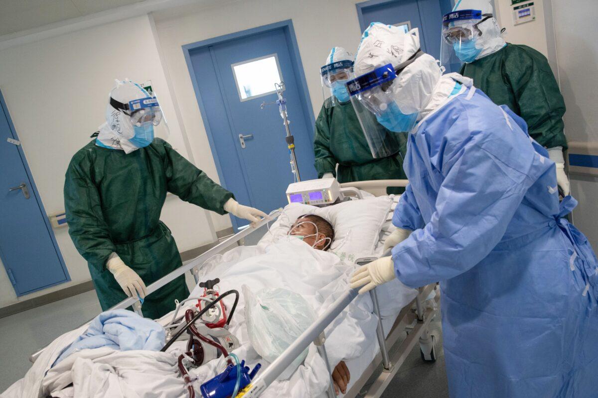 Medical staff transfer a patient infected by the Novel Coronavirus at a hospital in Wuhan in China's central Hubei province on Feb. 22, 2020. (STR/AFP via Getty Images)
