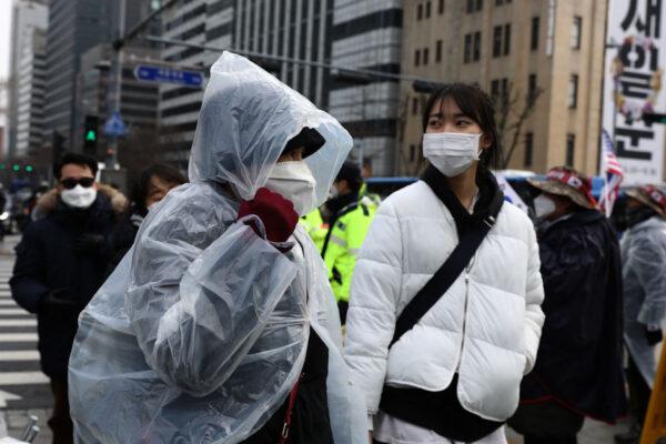 People wear masks to prevent the novel coronavirus walk along the street in Seoul, South Korea, on Feb. 22, 2020. (Chung Sung-Jun/Getty Images)