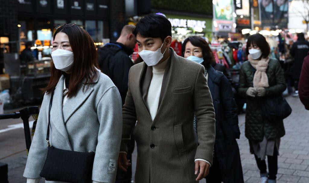 People wearing masks to prevent the novel coronavirus walk along the Myungdong shopping district in Seoul, South Korea, on Feb. 23, 2020. (Chung Sung-Jun/Getty Images)