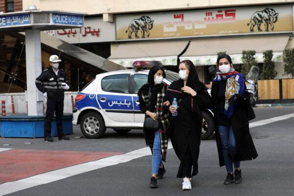 A policeman and pedestrians wear masks to help guard against the coronavirus in downtown Tehran, Iran, on Feb. 23, 2020. (Ebrahim Noroozi/AP Photo)