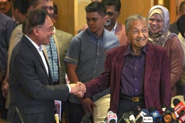 Malaysian Prime Minister Mahathir Mohamad shakes hand with successor Anwar Ibrahim in Putrajaya, Malaysia on Feb. 22, 2020. (Vincent Thian/AP Photo)