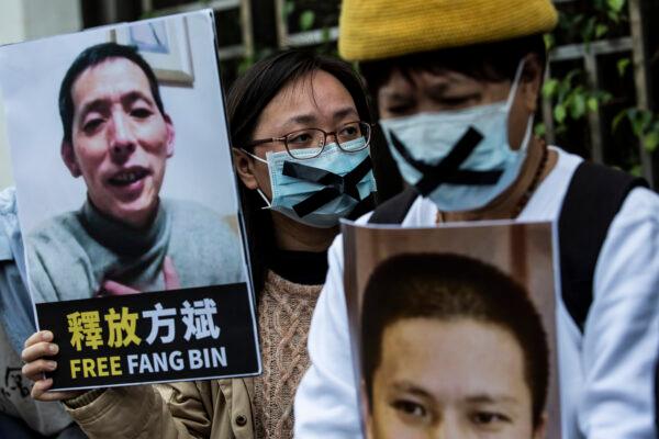 A pro-democracy activist (C) from HK Alliance holds a placard of missing citizen journalist Fang Bin, as she protests outside the Chinese liaison office in Hong Kong on Feb. 19, 2020. (Isaac Lawrence/AFP via Getty Images)