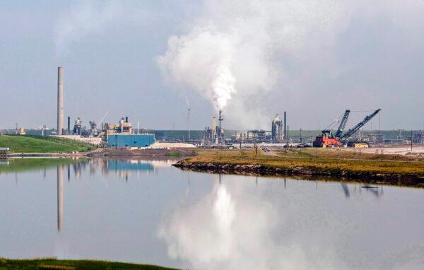An oil sands facility is reflected in a tailings pond near Fort McMurray, Alta., in a file photo. (The Canadian Press/Jeff McIntosh)