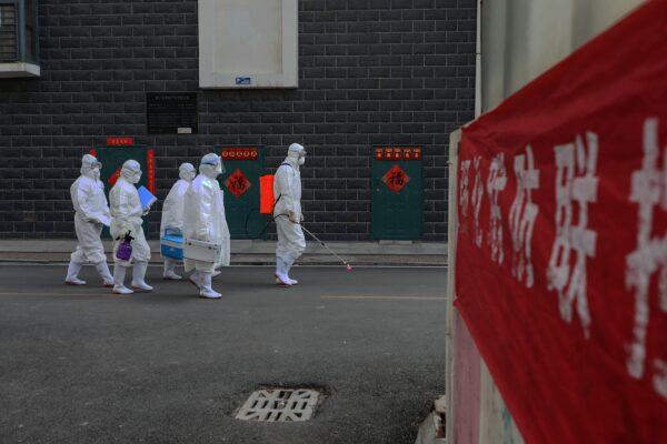 A group of laboratory technicians are making their way during an epidemiological investigation in Linyi city in Shandong, China on Feb. 10, 2020. (STR/AFP via Getty Images)