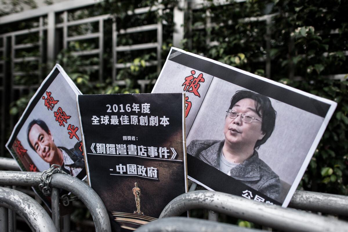 Placards showing missing bookseller Gui Minhai (R) are seen left by members of the Civic party outside the China liaison office in Hong Kong on Jan. 19, 2016. (Philippe Lopez/AFP via Getty Images)