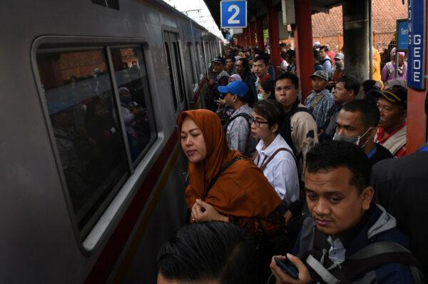 People wait for a commuter train during delays along the Jakarta-Bogor rail lines due to floods, at Bojong Gede Station, in Cibinong, near Jakarta, Indonesia, on Feb. 25, 2020. (Antara Foto/Muhammad Adimaja/via Reuters)