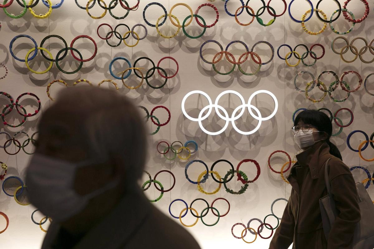 Two people wear masks as they visit the newly opened Japan Olympic Museum located near the New National Stadium in Tokyo, Japan, on Feb. 23, 2020. (Jae C. Hong/AP Photo)