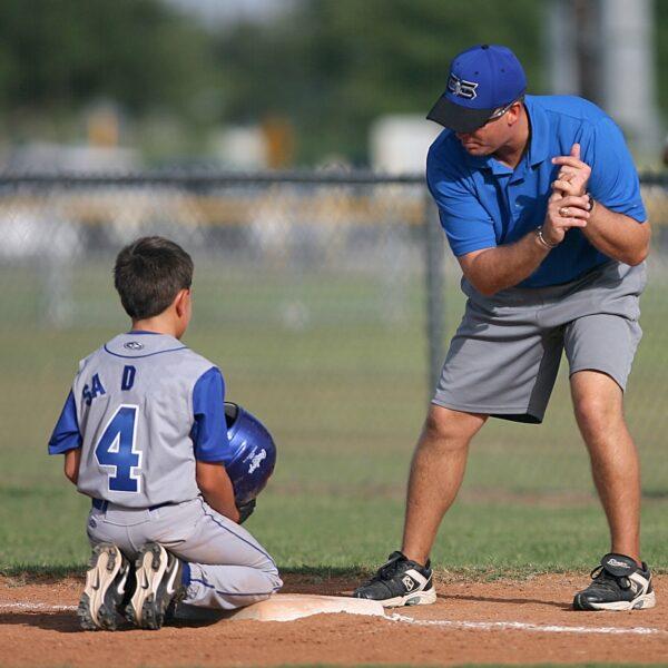 A file photo of a young baseball player and coach. (Pexels)