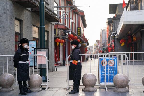 Chinese security guards wear protective masks as they stand on an empty commercial street in Beijing on Feb. 25, 2020. (Lintao Zhang/Getty Images)