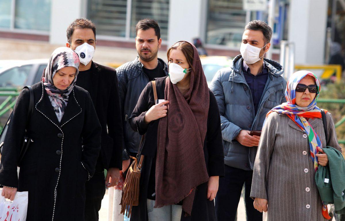 Iranians, some wearing protective masks, wait to cross a street in the capital Tehran on Feb. 22, 2020. (Atta Kenare/AFP via Getty Images)