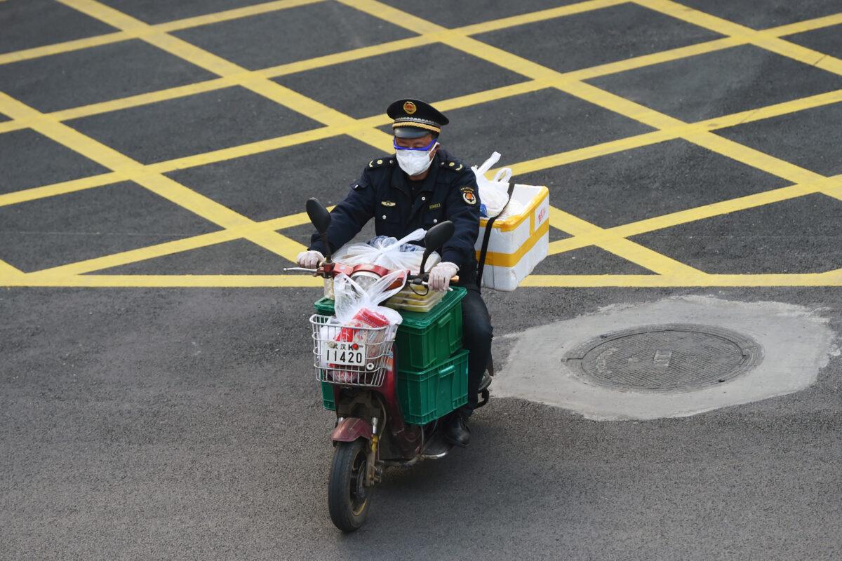 A man wearing a face mask rides a bike filled with food supplies in Wuhan, the epicenter of the Novel Coronavirus outbreak, Hubei province, China, on Feb. 24, 2020. (Stringer/Reuters)