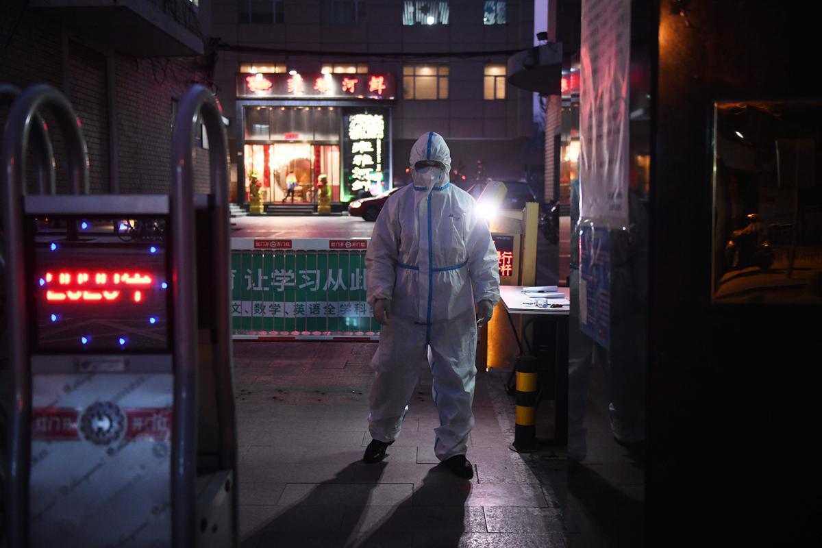 A security guard wears protective clothing as a preventive measure against the COVID-19 coronavirus as he stands at the entrance of a restaurant in Beijing, China, on Feb. 25, 2020. (Greg Baker/AFP via Getty Images)