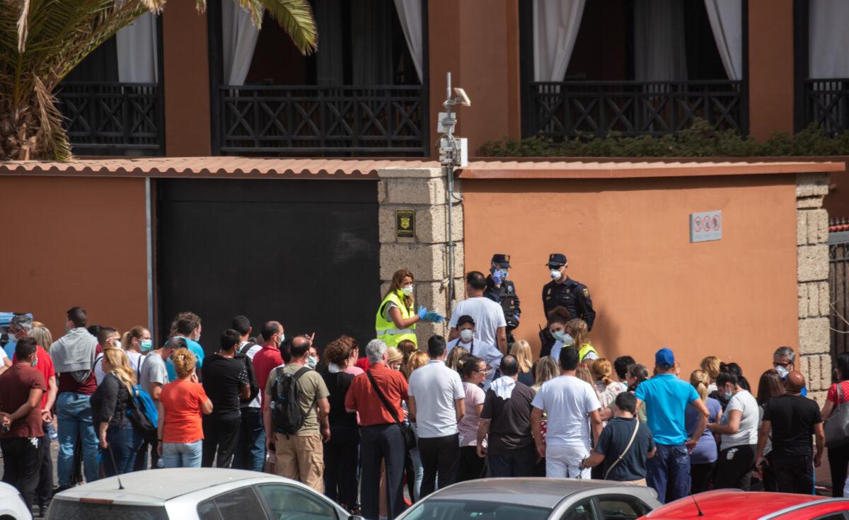 A psychologist talks to a group of workers outside the H10 Costa Adeje Palace Hotel in La Caleta, on Feb. 25, 2020, where hundreds of people were confined after an Italian tourist was hospitalised with a suspected case of coronavirus. (Desiree Martin/AFP via Getty Images)