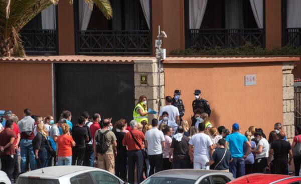 A psychologist talks to a group of workers outside the H10 Costa Adeje Palace Hotel in La Caleta, Italy, on Feb. 25, 2020. (Desiree Martin/AFP via Getty Images)