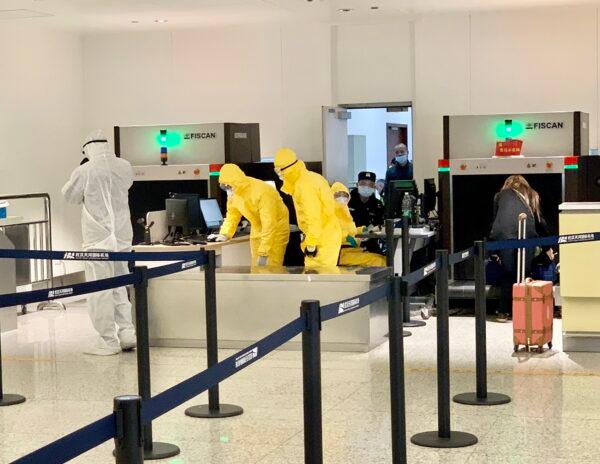 Airport staff dressed in protective suits handling luggage of evacuated passengers at Wuhan Tianhe Airport in Wuhan, China, on Feb. 4, 2020. (Courtesy of David)