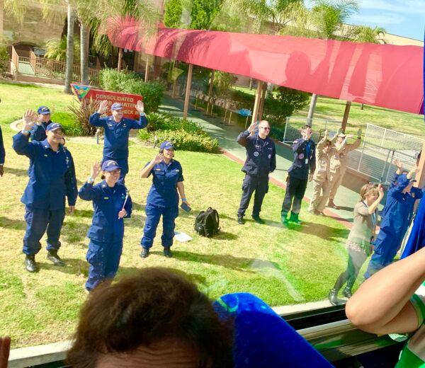 Working staff wave to departing quarantined passengers who are free of the coronavirus, at the Marine Corps Air Station in Miramar, California, on Feb. 18, 2020. (Courtesy of David)