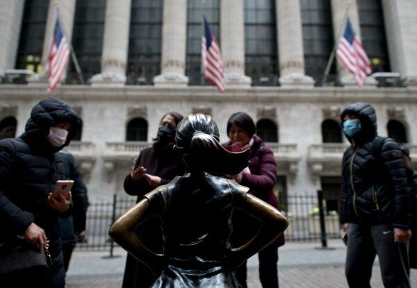 Chinese tourists with facial masks stand in front of the New York Stock Exchange at Wall Street in New York City on Feb. 3, 2020. (Johannes Eisele/AFP via Getty Images)
