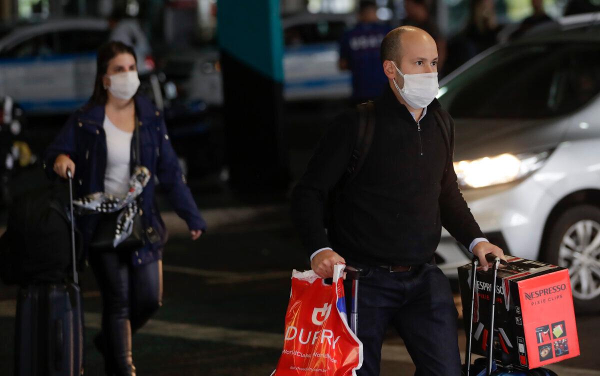 Airport Passengers wearing masks as a precaution against the spread of the new coronavirus COVID-19 at the Sao Paulo International Airport in Sao Paulo, Brazil on Feb. 26, 2020. (Andre Penner/AP Photo)