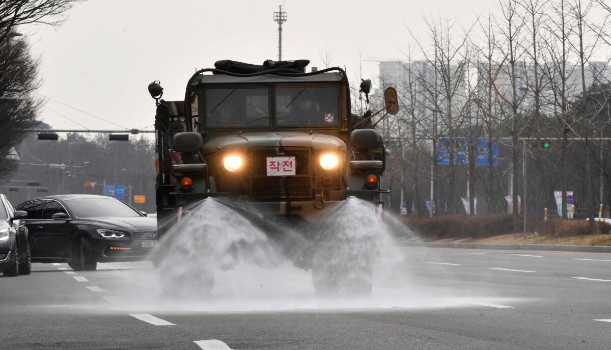 Soldiers in a military truck spray disinfectant as a precaution against the COVID-19 on the street in Gwangju, South Korea, on Feb. 11, 2020. (Shin Dae-hee/Newsis via AP)