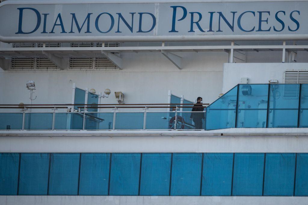 A crew member wearing a face mask walks on the deck of the Diamond Princess cruise ship at Daikoku pier cruise terminal in Yokohama, Japan, on Feb. 24, 2020. (Philip Fong/AFP via Getty Images)