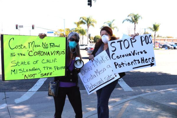 Local residents Kelly Depledge (L) and Jennifer Sterling (R) protest the plan to move coronavirus patients to the Fairview Developmental Center in Costa Mesa, Calif., on Feb. 25, 2020. (Jamie Joseph/The Epoch Times)