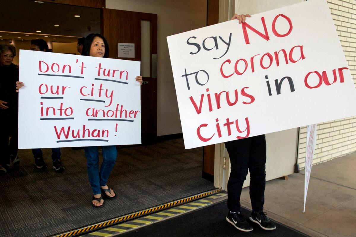 In this Feb. 22, 2020 file photo, Mary Cahill, left, leaves a news conference where officials discussed the proposal for housing coronavirus patients at the Fairview Development Center in Costa Mesa, Calif. (Mindy Schauer/The Orange County Register via AP, File)