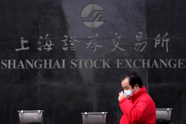 A man wearing a mask walk past the Shanghai Stock Exchange building at the Pudong financial district in Shanghai, China, on Feb. 3, 2020. (Aly Song/Reuters)