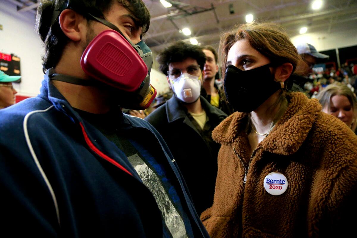 Concerned about the spread of COVID-19 in large gatherings, students from the University of North Carolina School of the Arts wear respiratory masks as they wait for Democratic presidential candidate Sen. Bernie Sanders (I-Vt.) to speak to supporters during a rally and march to early vote in Winston-Salem, N.C., on Feb. 27, 2020. (Brian Blanco/Getty Images)